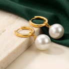 Detalj av Liora Earrings Gold på elfenbensfärgad sten med mörkgrönt siden
