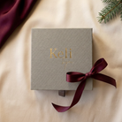 Pearl Glow Gold, stängd adventskalender på champagnefärgat siden med vinrött band